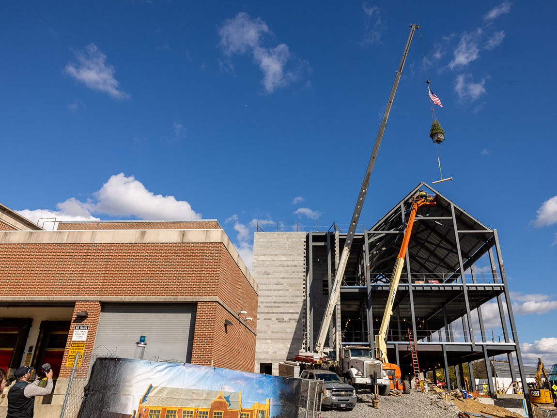 A crane lifts a beam onto the top of a new steel structure